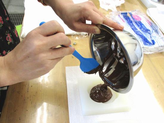 画像：チョコレートを青銅鏡型に流し込む
