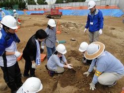 出土した遺物に集まる参加者